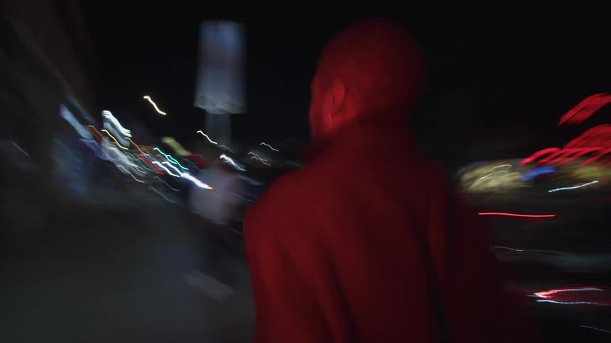 A man walks through a metropolis at night