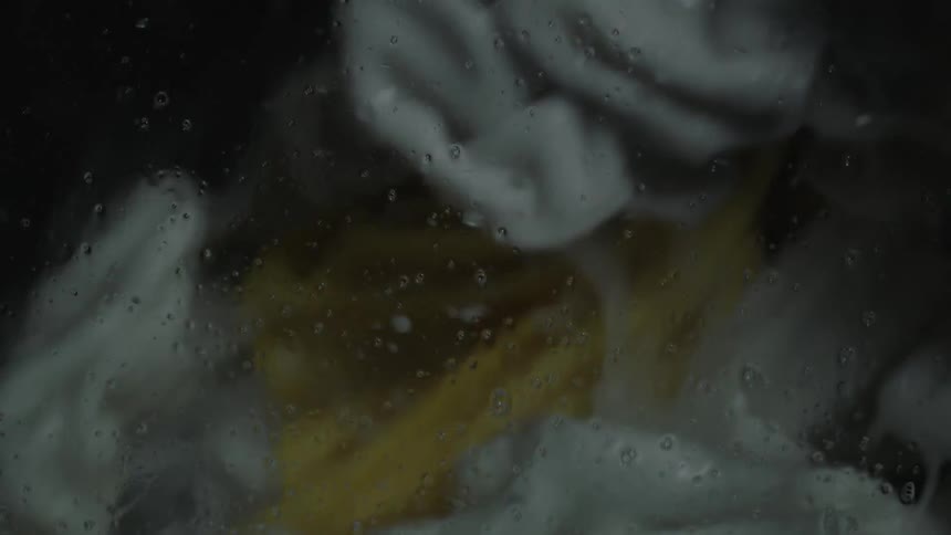 Clothes are tumbling in a washing machine
