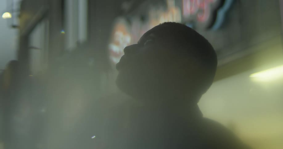 Side profile of man wearing black coat looking up in the street