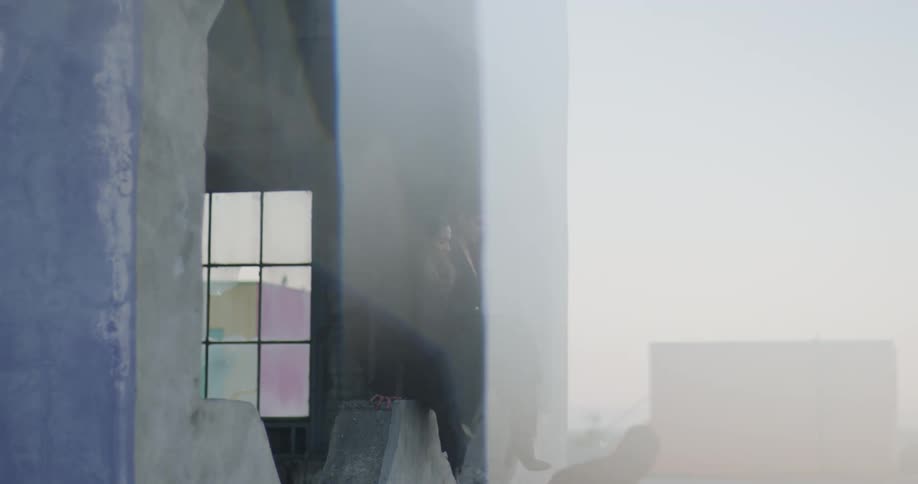 A group of friends climb onto a building rooftop