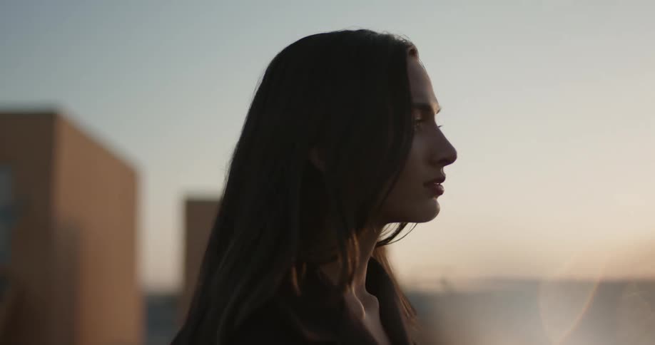 A man and woman in black stand outside staring ahead at something