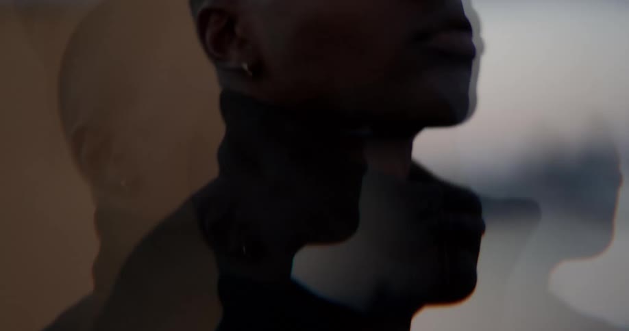 Multiple images of same person move past building while looking upward