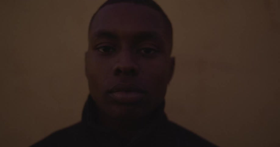 Red colored lighting flashes illuminating mans face as he stares