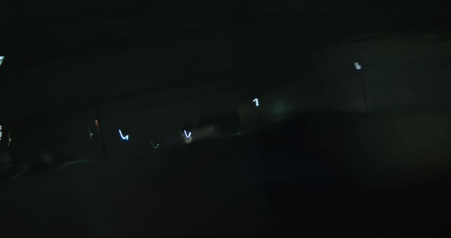 A parking garage and nearby downtown buildings are lit up at night