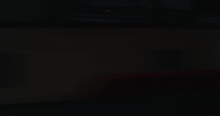 Shaky pov riding in car at nighttime and seeing the lights and buildings rushing by