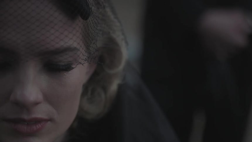 A woman wearing a black veil looks around