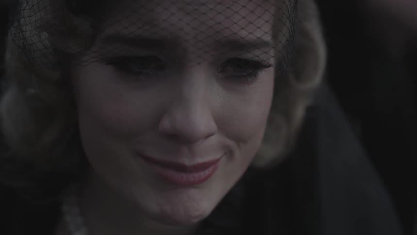 Grieving blonde woman wearing a partial veil