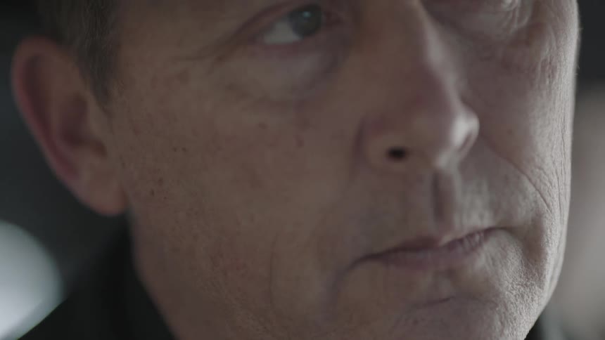 A man in black looks down