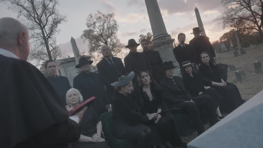 Mourners at a funeral listen to a clergyman