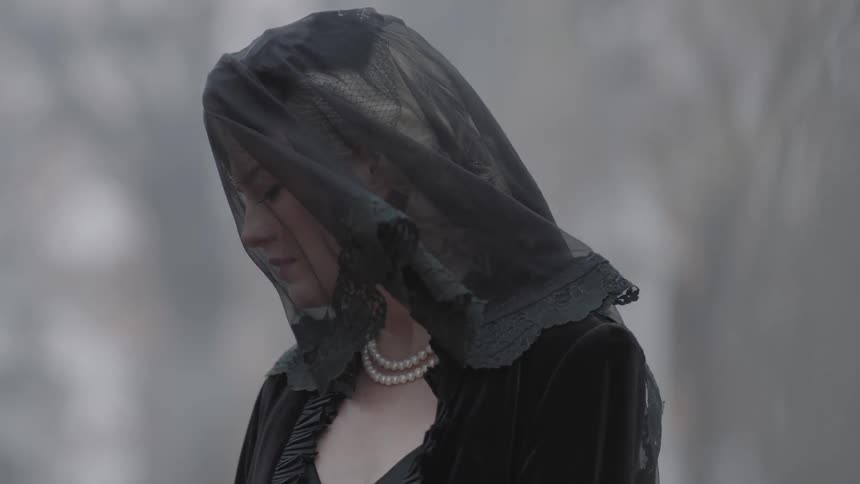 Leaves blow against a woman in black