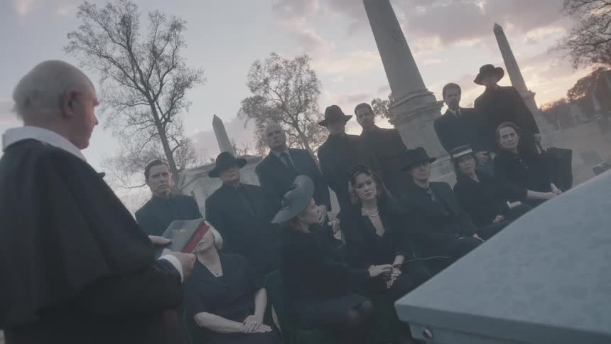 People are at a funeral near sunset