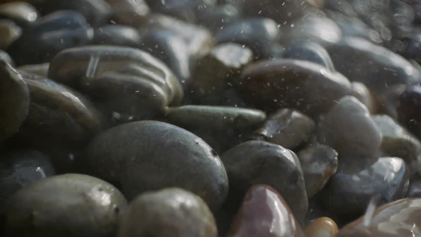 Raindrops Dance: Water Splashes on Smooth Stones