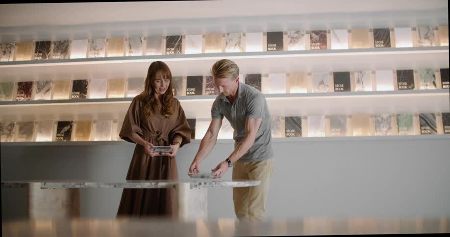 Man and woman in retail store woman showing man products including stone books they each point to things