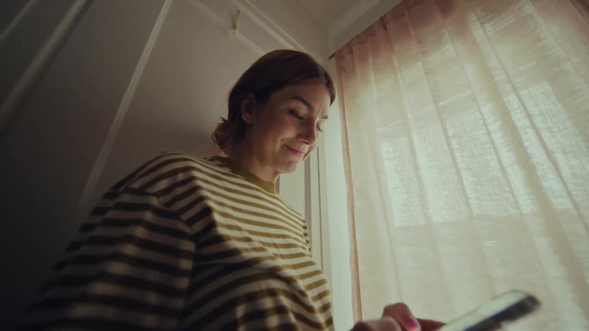 A woman is typing on her cell phone