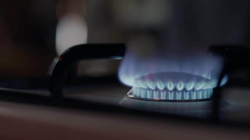 Igniting the Blue Flame: Closeup of Lighting a Gas Burner on Stove