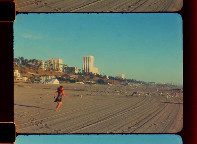 The view is of a woman that is running down the beach in day time