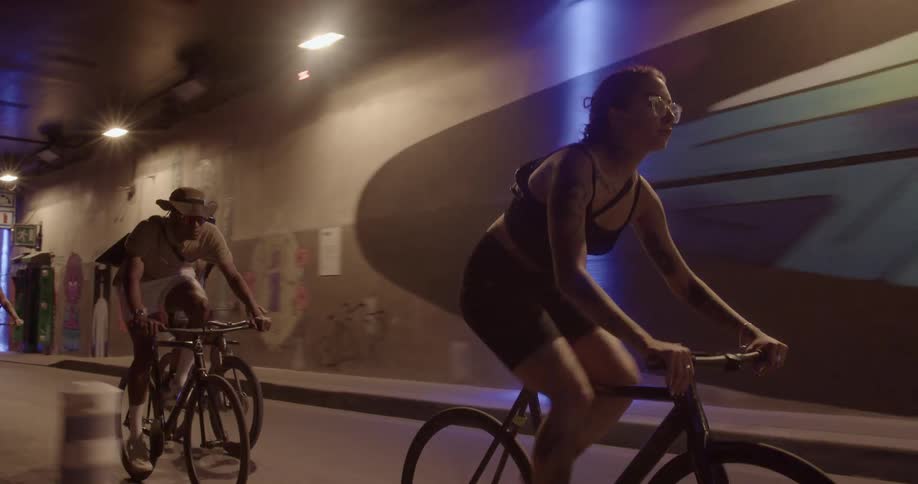 Three friends are biking on tarmac during the night time