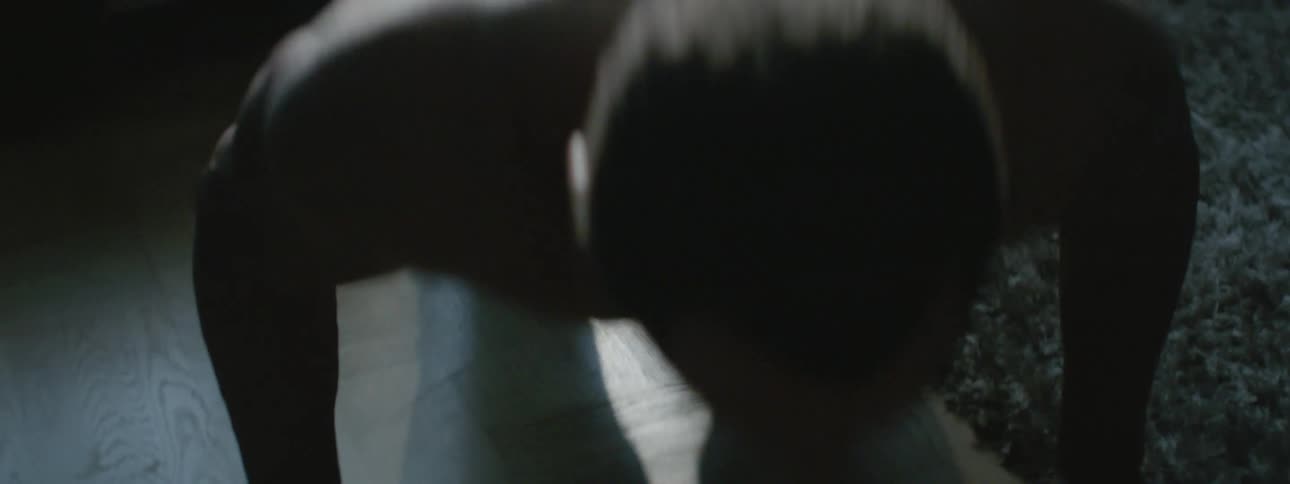 A man does push ups on his living room floor