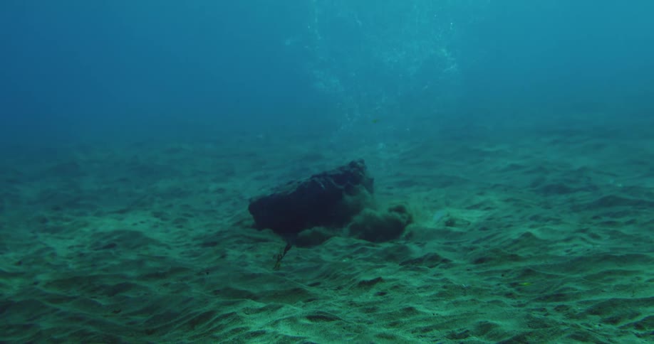 A large rock sinking to the bottom of the ocean