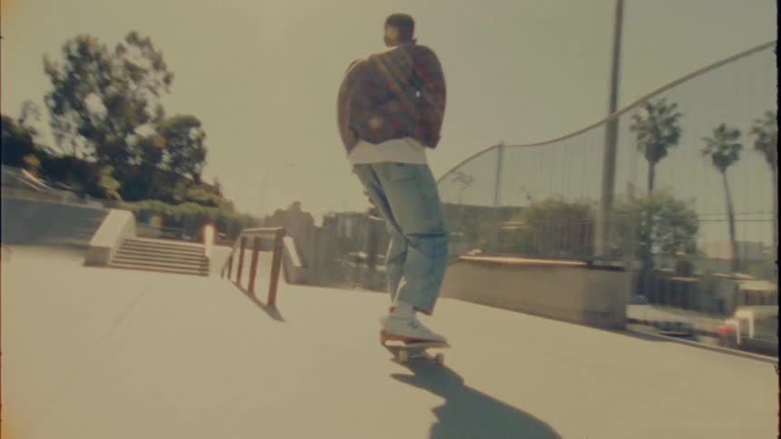 A man rides his skateboard through a skate park