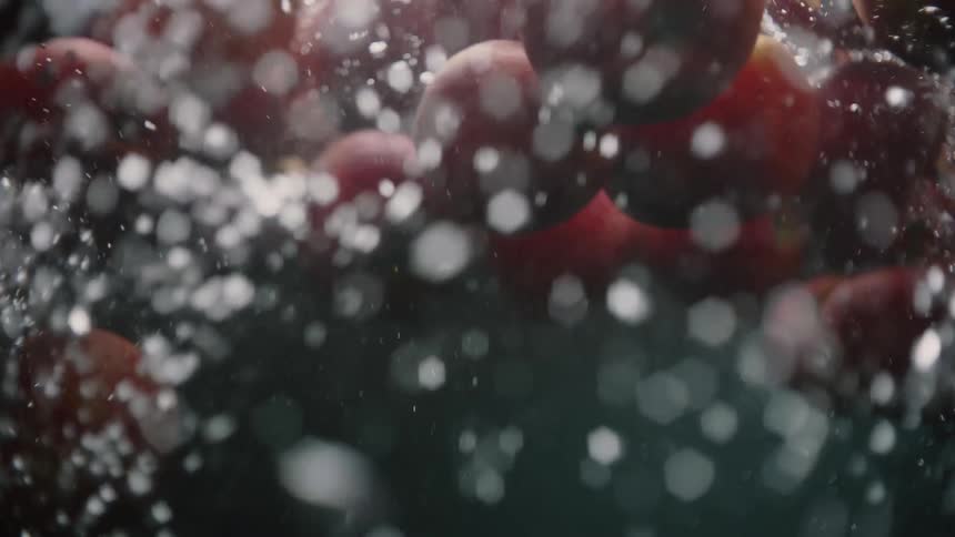 Vibrant Apple Splash: Red Apples Submerged in Clear Water, Creating Air Bubbles