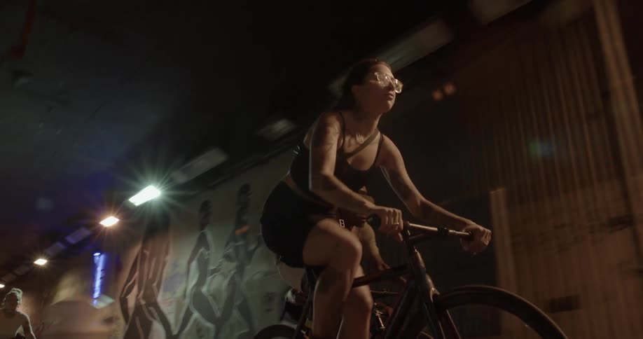 A woman biking with people in a tunnel