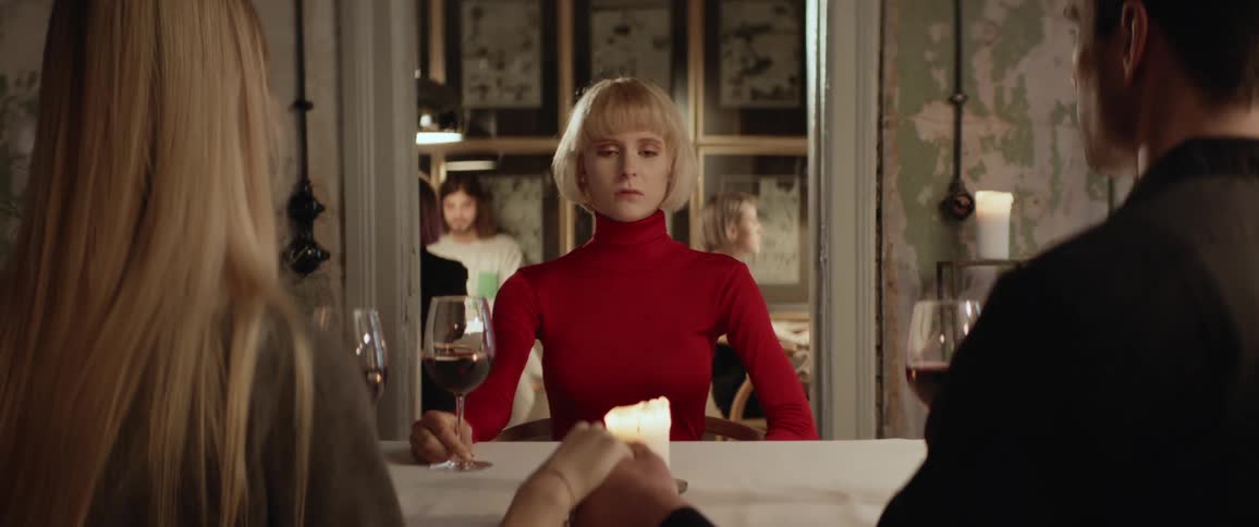 A family hold hands to say before eating at a restaurant