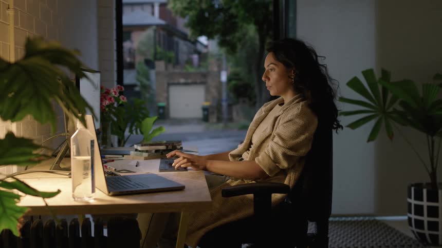 A young woman is working in the office and is on her laptop