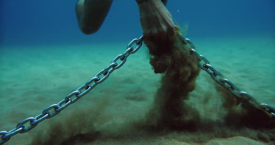 A young man is swimming under the ocean in the day time