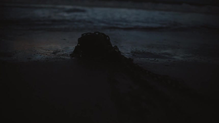 Silhouette of a heap of chains on the sand beach at night next to the ocean