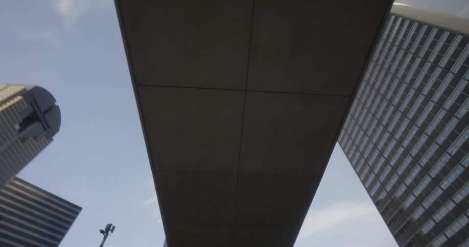 A pedestrian overpass on the city skyline against the blue sky at evening