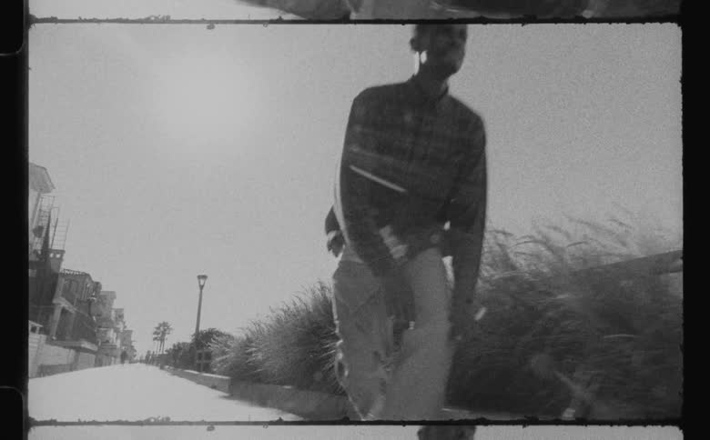 Film footage of a male skateboarding outdoors