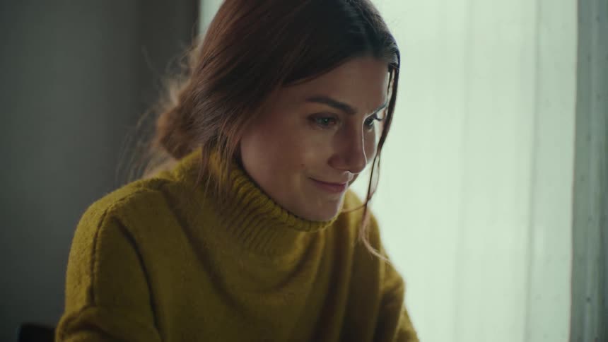 A woman is typing on her laptop