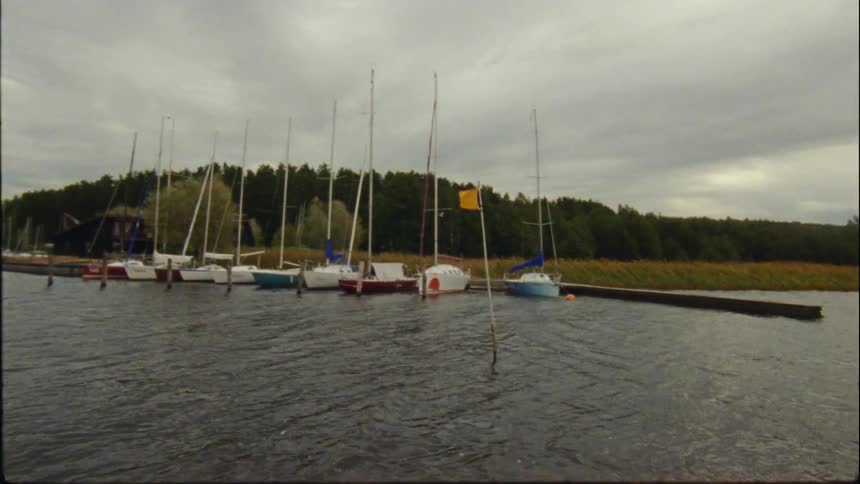Multiple boats are parked at the dock during sunset