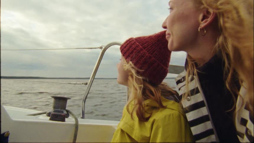 A mother and kid are on a boat in the middle of the day time