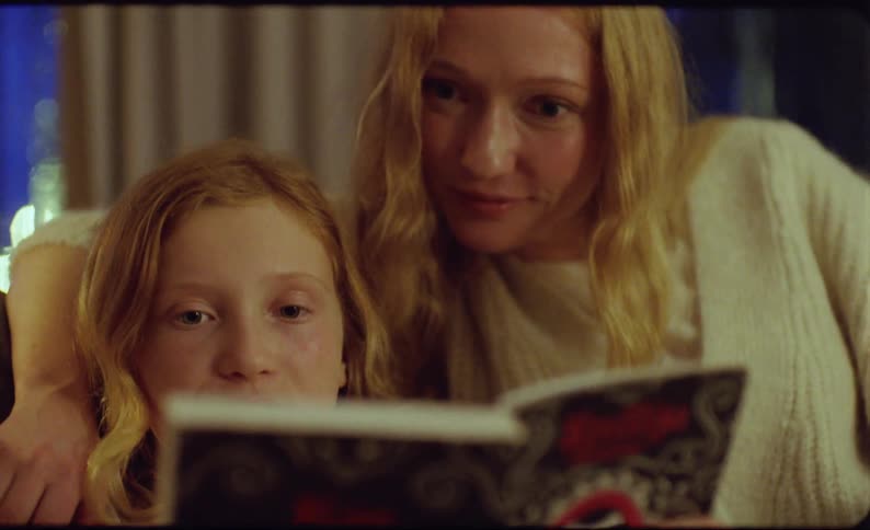 Mother and daughter are reading a book together