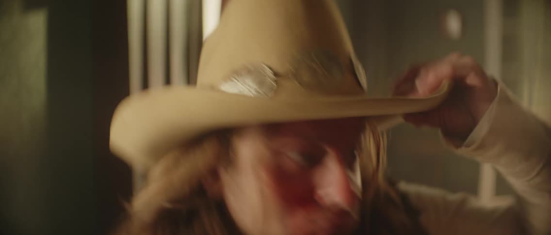 A cowboy looks fearful and runs out of a building