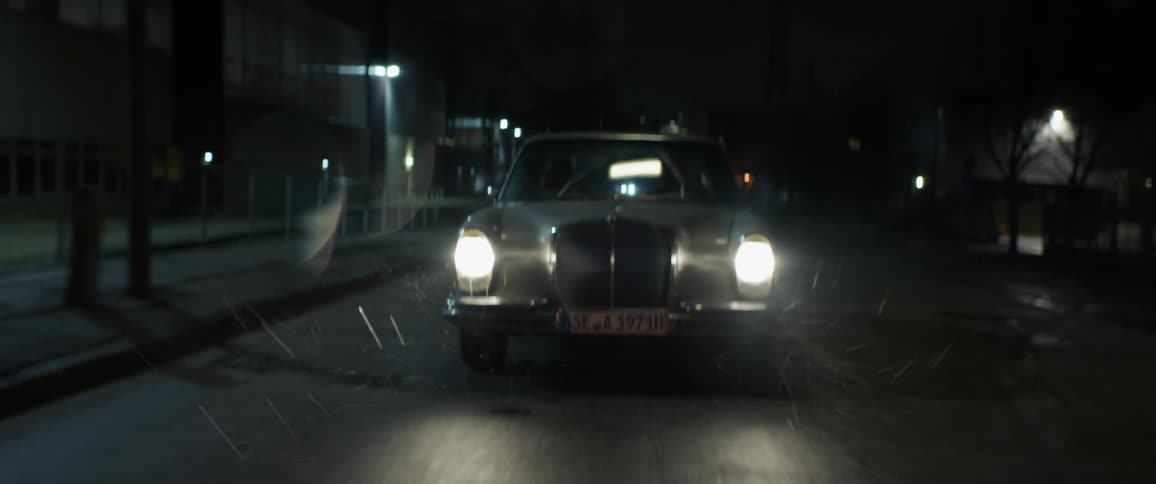 Old classic car drives on highway while raining at night