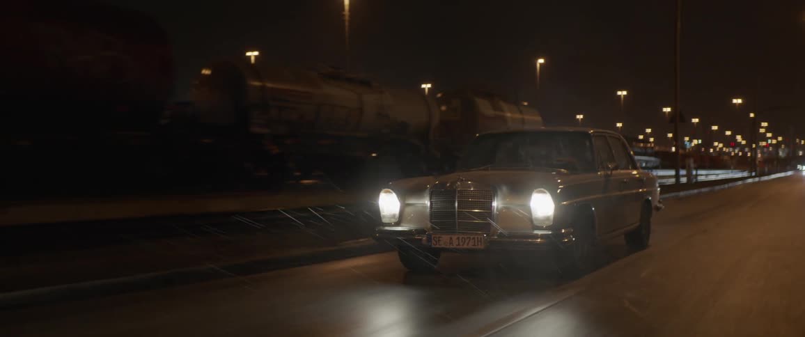 Young couple driving a vintage car on the rain in the highway at night