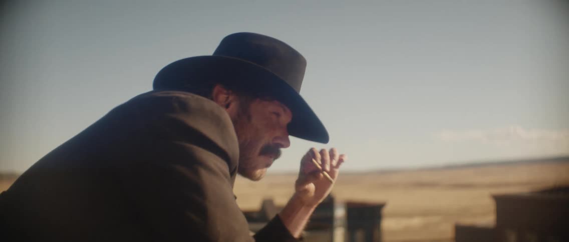 An older man is outdoors and is shooting a gun