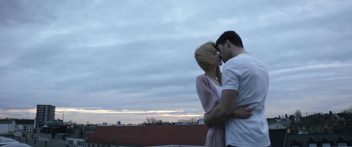 Man and woman are standing outdoors and kissing
