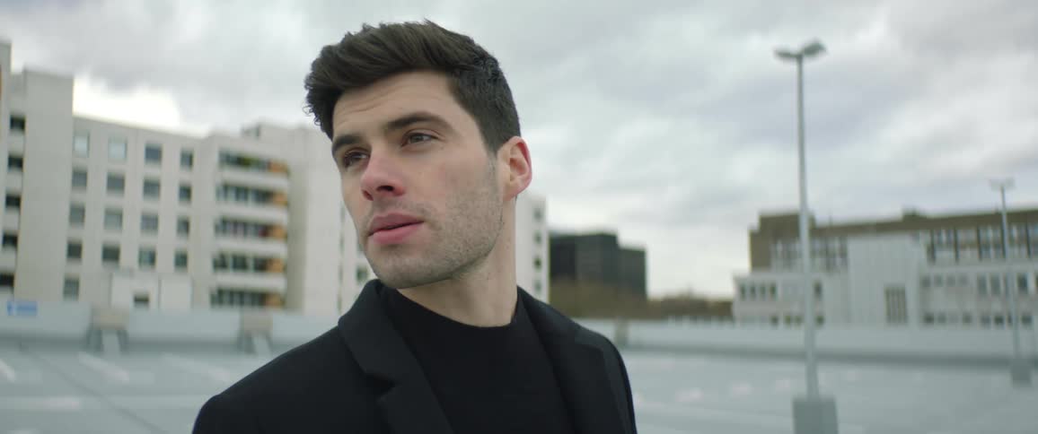 The view is of a man smoking outdoors around the city area