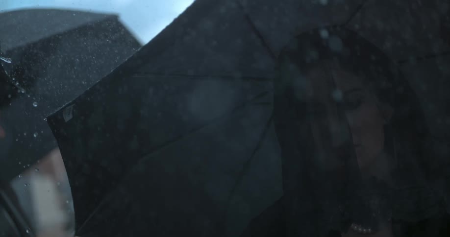 Rain falls on a woman in black