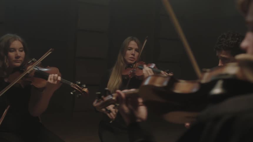 A group of people playing instruments in a dark room