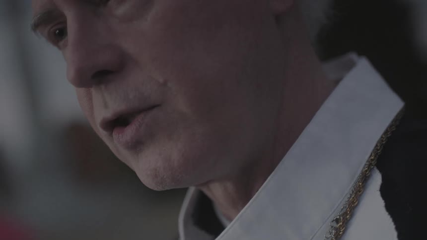 A priest is speaking out doors