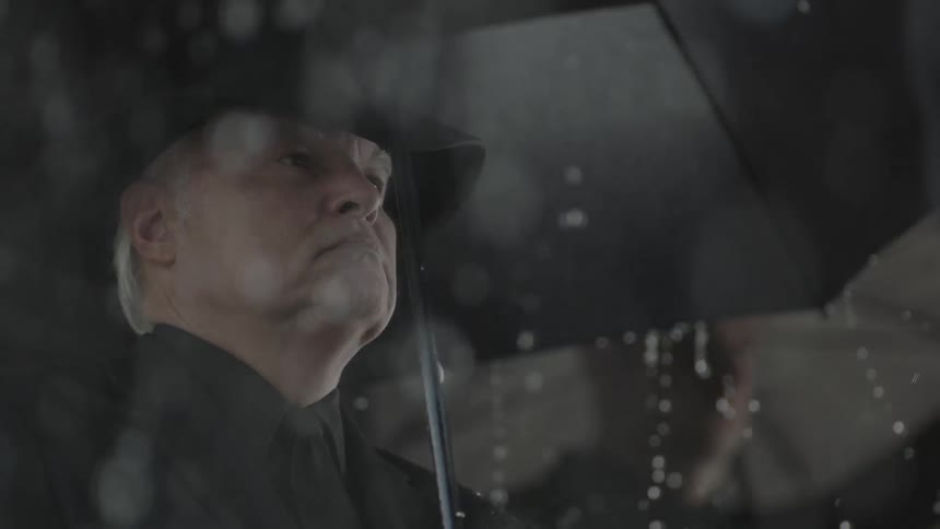 People stand outside with umbrellas in the rain