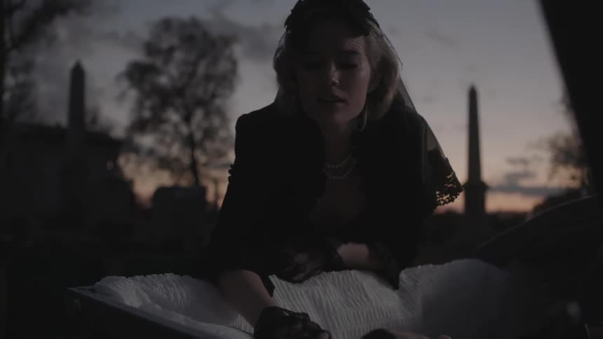 Woman mourns over an open casket