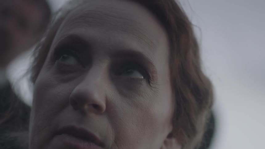 A woman opens her eyes slowly looking up