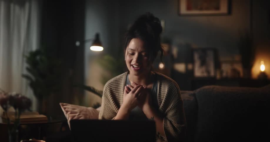 A woman uses her laptop for a video call at home