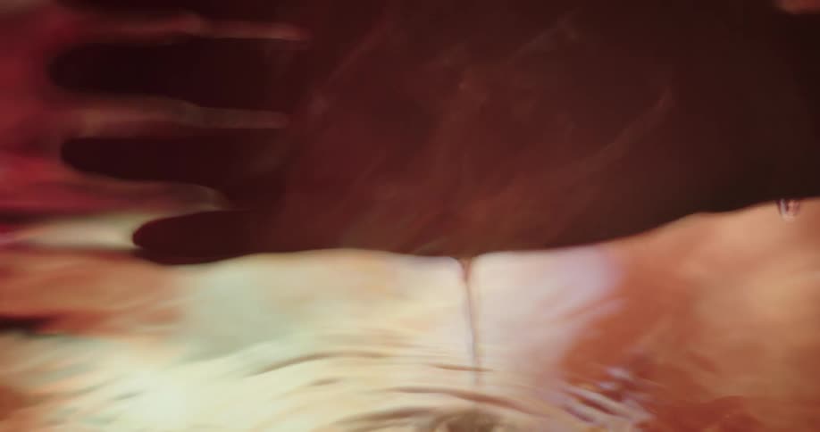 A person dipping their hand in rippling water